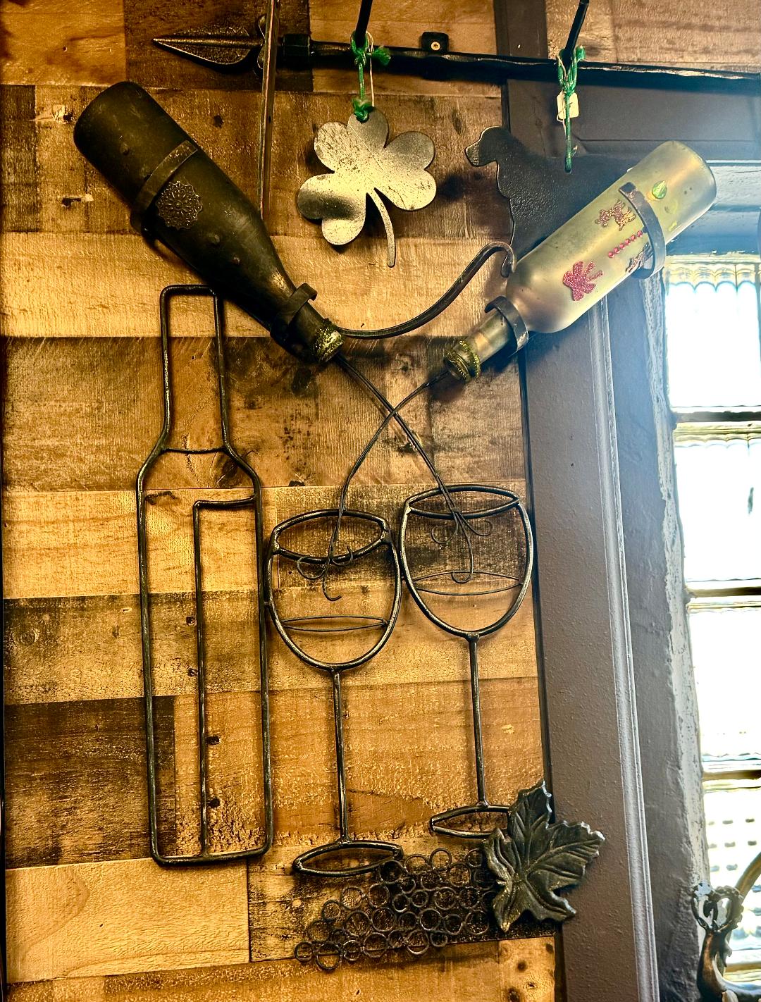 Metal wine racks with artistic designs, showcasing two wine glasses, g ...